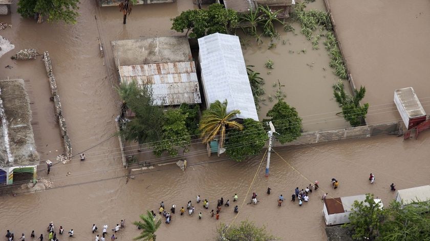 People make their way through flooding caused by Tropical Storm Hanna in Gonaives, Haiti