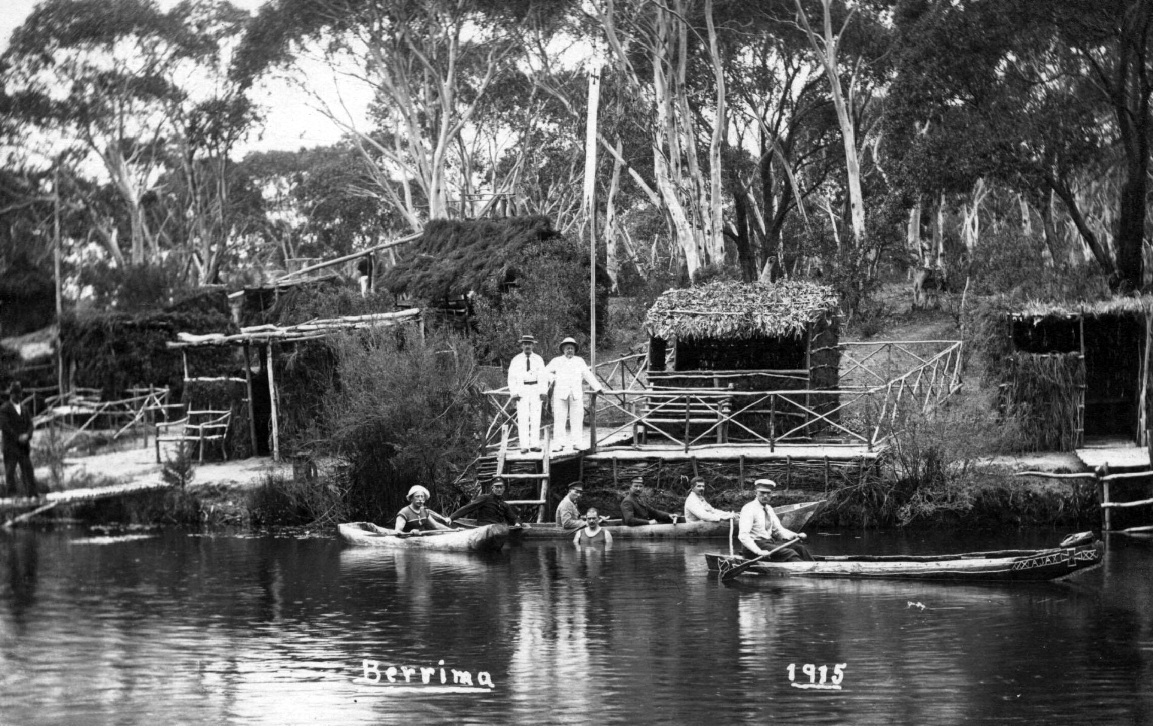 Small group of men in boats on water and standing on hut deck