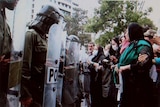 A group of Iranian women face off against riot police in Tehran