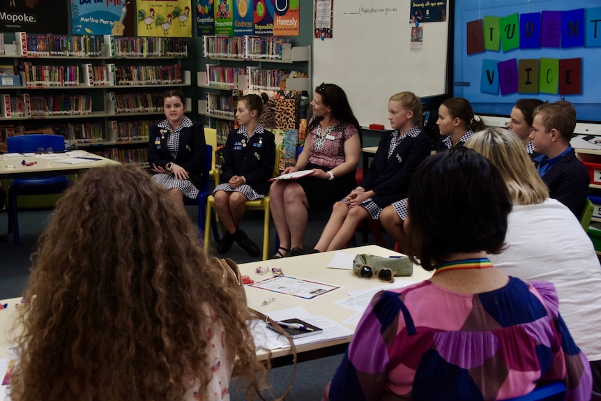 School kids speak in a circle.