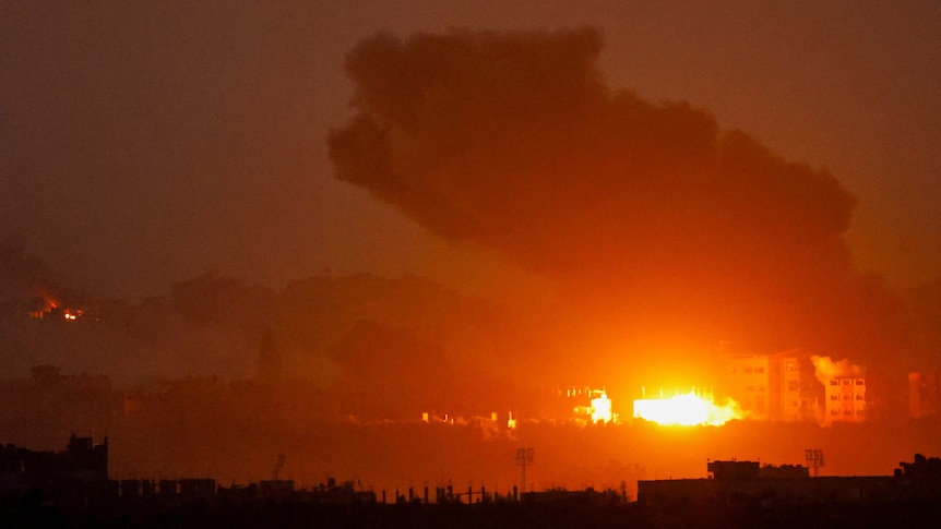 smoke billows into the sky while an explosion is seen in gaza