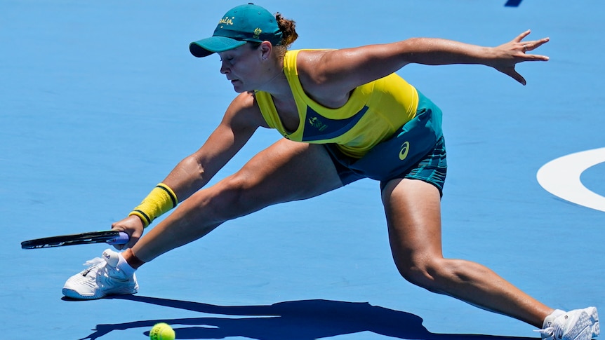 Ash Barty leans at full stretch to get her racquet to the ball during a point at the Olympics.