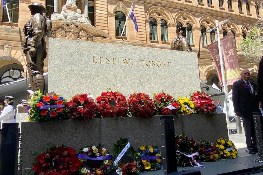 Floral wreaths laid at a cenotaph.