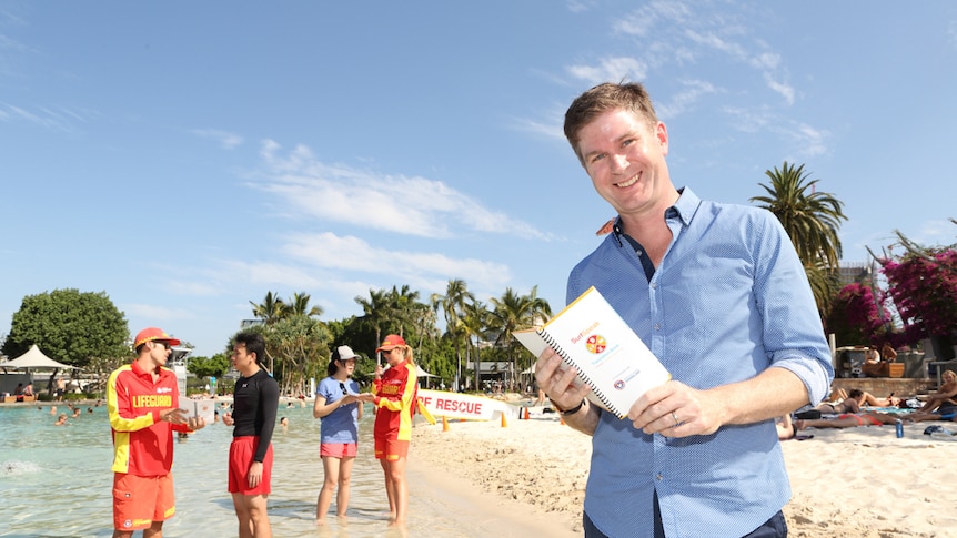 Creator Mark Schroder with Australia's first booklet to help overcome language barriers to help surf safety.
