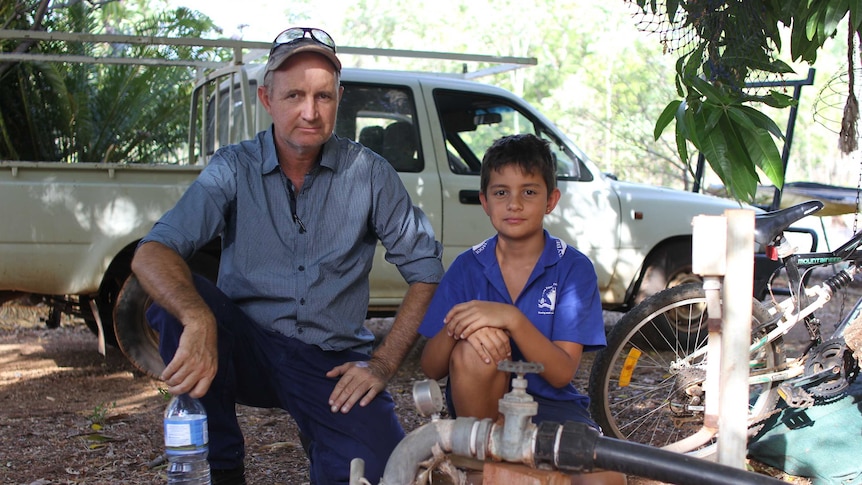 A man and a boy next to a water bore