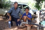 A man and a boy next to a water bore