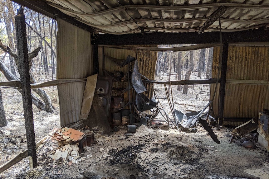 The inside of a blackened and warped shed.