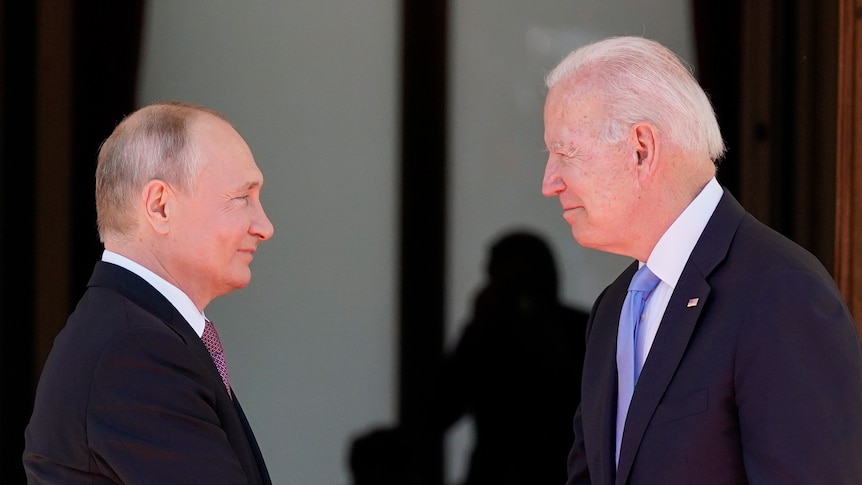 Joe Biden and Vladimir Putin shake hands. 