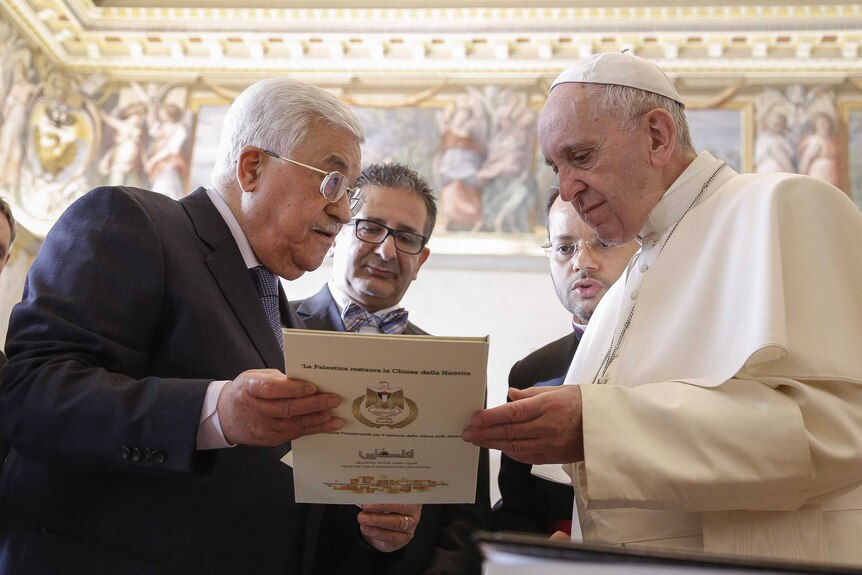 Mahmoud Abbas presents Pope Francis with a gift.