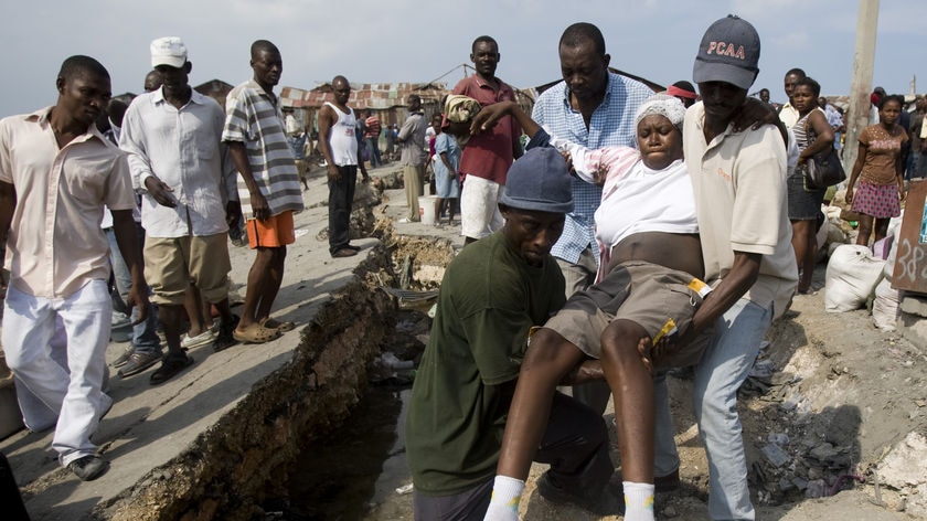 Haitians carry a pregnant woman through Port-au-Prince