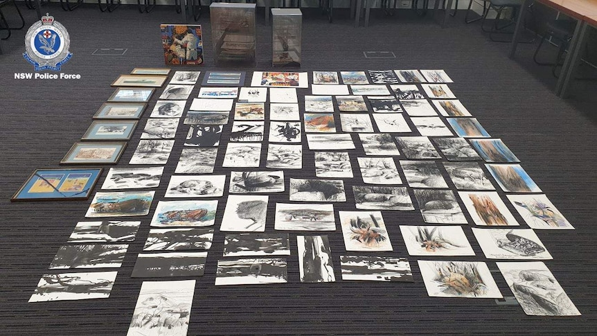 Dozens of small artworks laying on the floor.