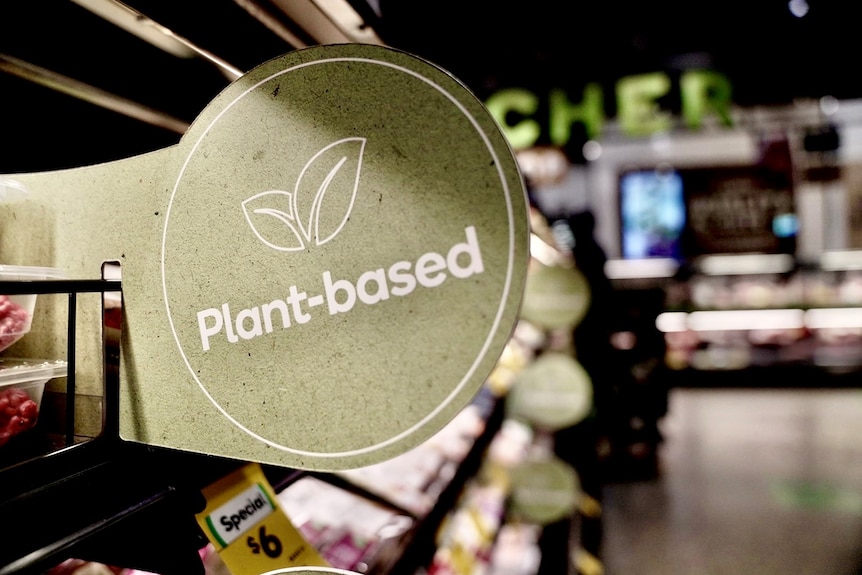 Plant-based food sign at Woolworths, with end of word 'butcher' in the background.