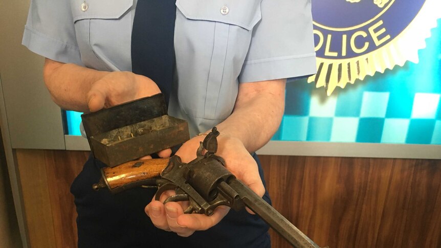 Policewoman holding antique gun handed in