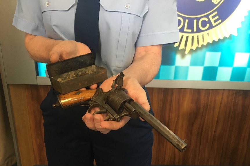 Policewoman holding antique gun handed in