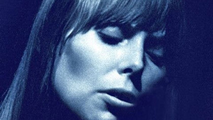 A blue, close up photo of Joni Mitchell with her eyes closed.