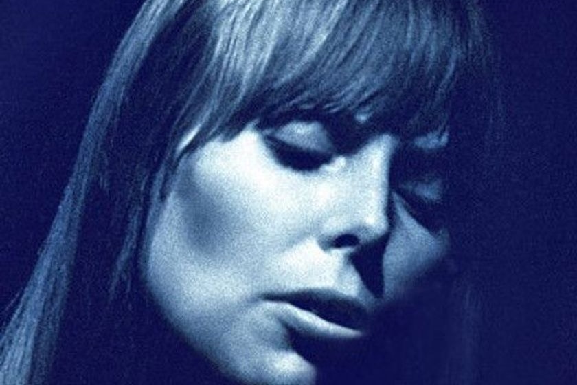 A blue, close up photo of Joni Mitchell with her eyes closed.