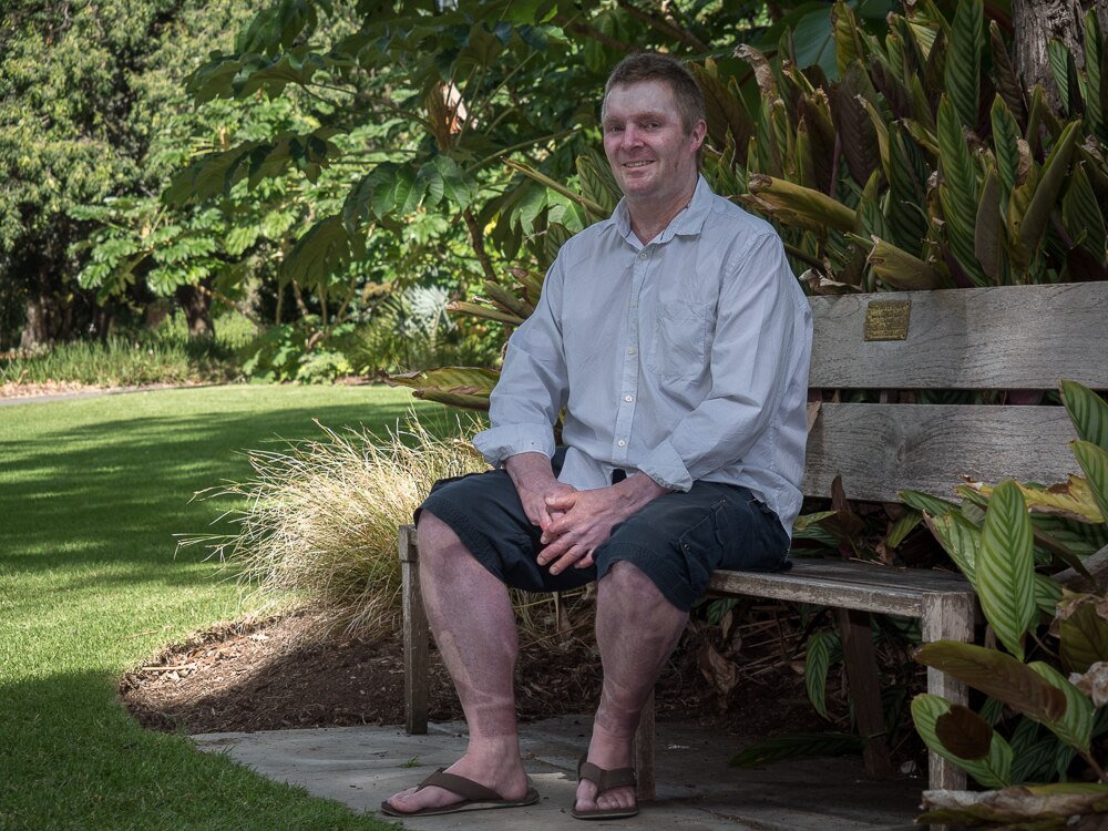 John Weeks sits on a bench in the Adelaide Botanic Gardens.