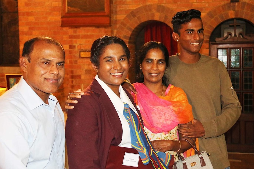 Soumiga Gopalakrishnan, dressed in her school uniform, with her family at her graduation mass in Brisbane.