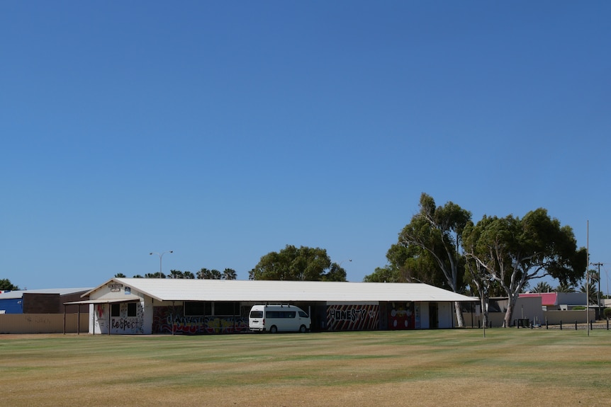 A pavilion is visible across a grass field. 