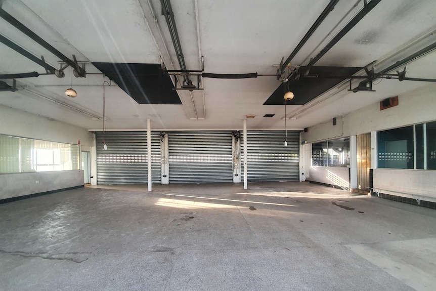 A vacant parking space with closed roller doors.