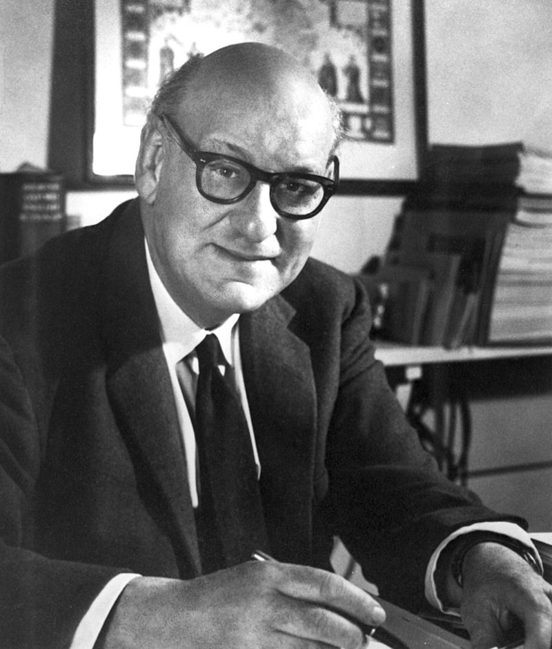 A black and white portrait of Australian biochemist Hedley Marston, sitting at his desk.