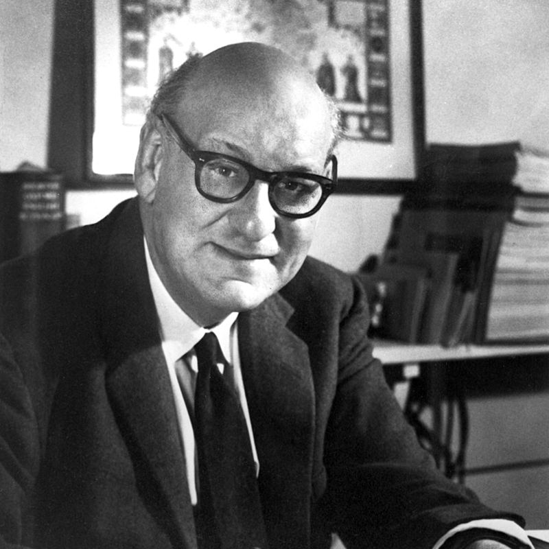 A black and white portrait of Australian biochemist Hedley Marston, sitting at his desk.
