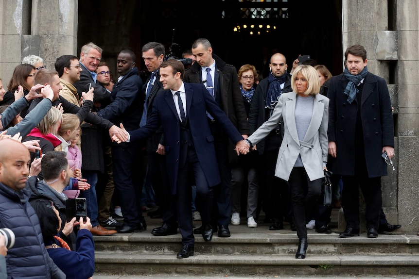 Emmanuel Macron and wife Brigitte leave a polling station.