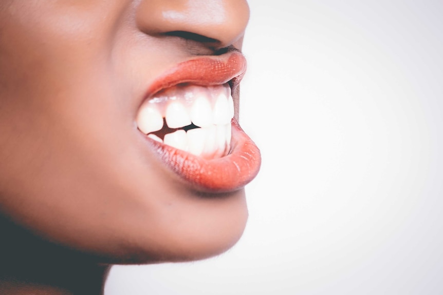 Woman bites her front teeth together.
