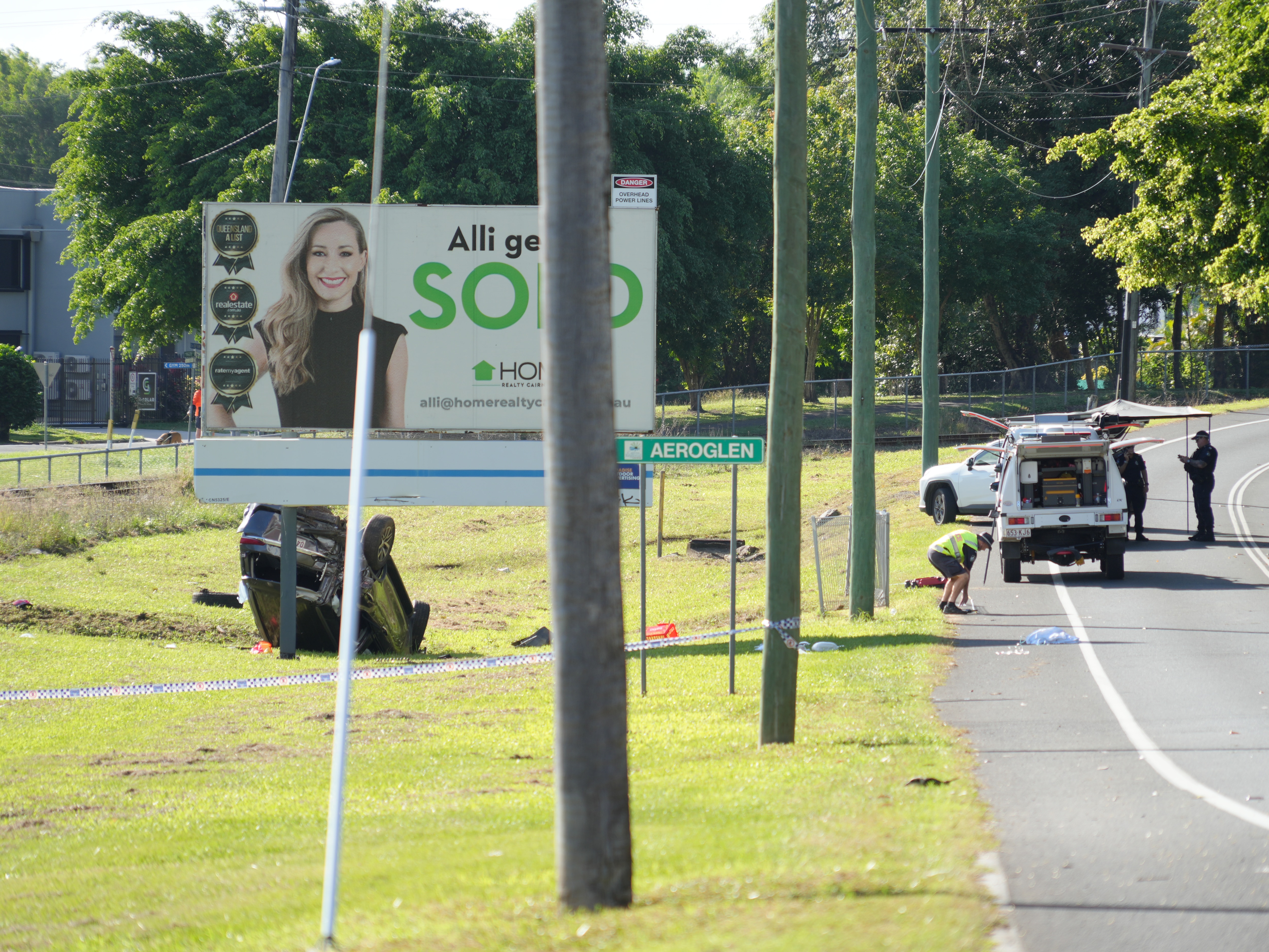 A car on its roof beside a road in Cairns.