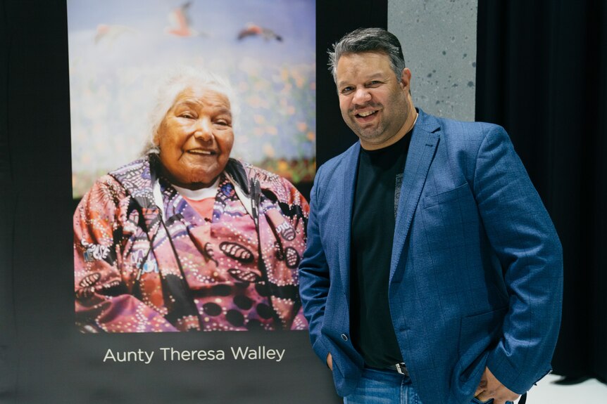 Phil Walleystack at the launch of Ngaluk Waangkiny with a portrait of the Aunty Theresa Walley
