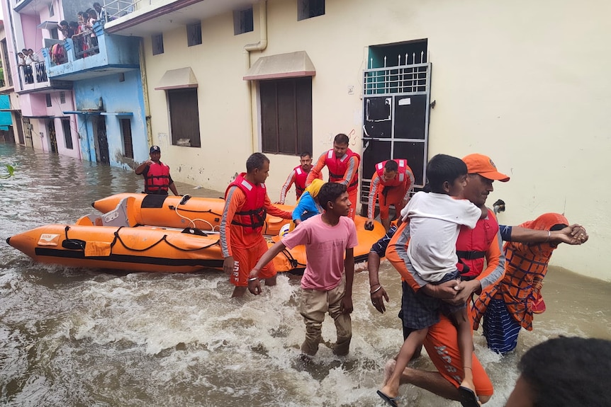 Officials evacuate people from flooded streets and homes in Uttarakhand, October 19, 2021.