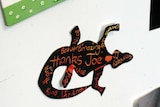 A thank you note on a fridge in the shape of a goanna.