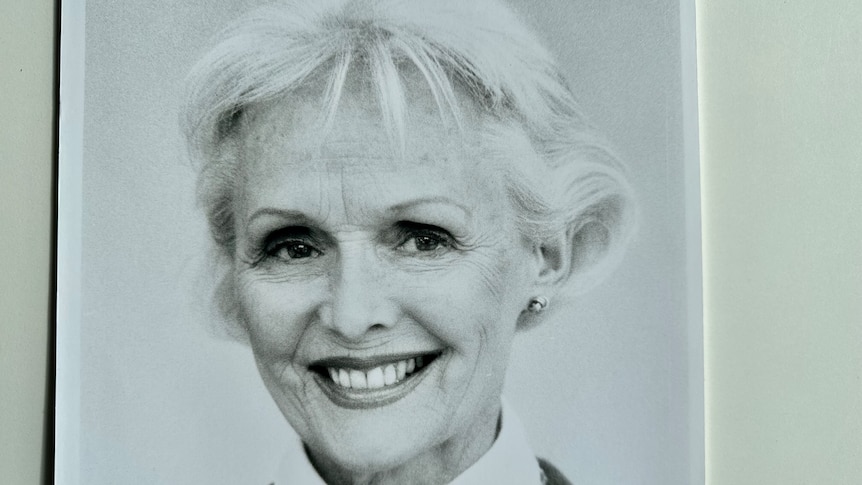 A black and white portrait of a woman smiling. 