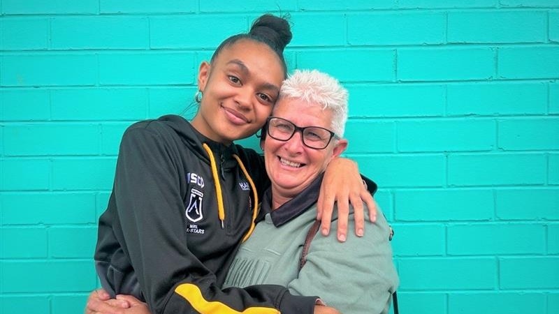 Indigenous woman and her teacher in an embrace