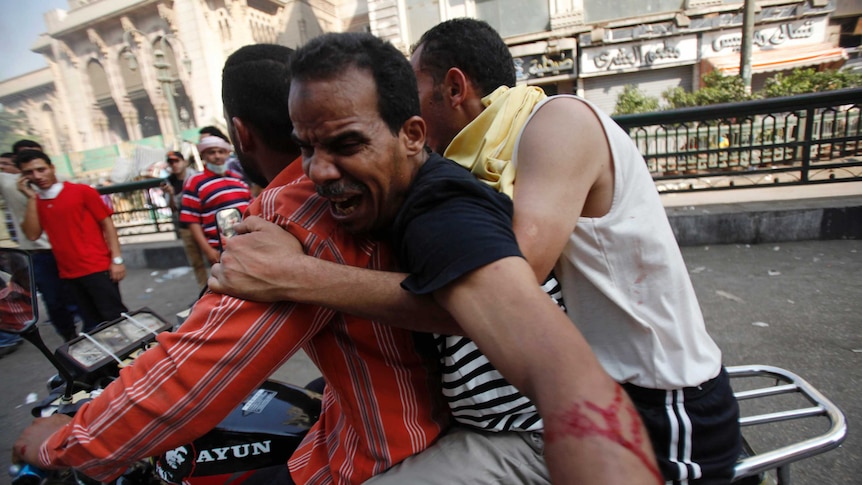 Morsi supporters carry injured demonstrator