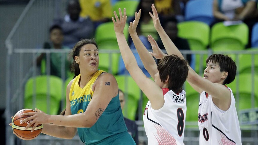 Australia centre Liz Cambage looks to pass around Japan's Maki Takada and Ramu Tokashiki.