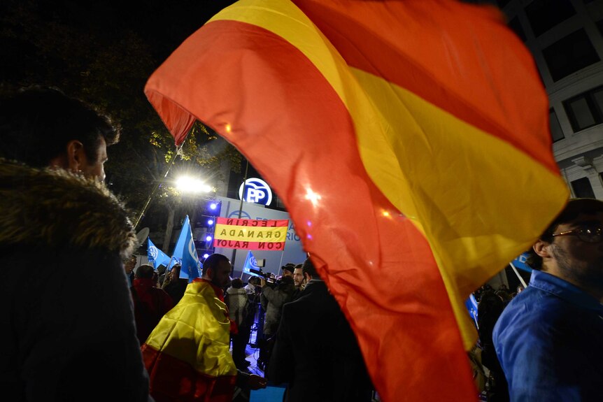 Popular Party supporter with Spanish flag at party headquarters in Madrid