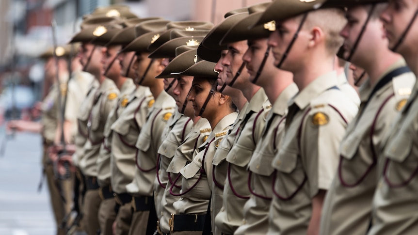 Australian Army soldiers stand at attention during an Anzac Day parade