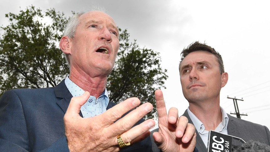 Steve Dickson gestures with his hands while James Ashby looks at him. The shot is from a low angle underneath the men.
