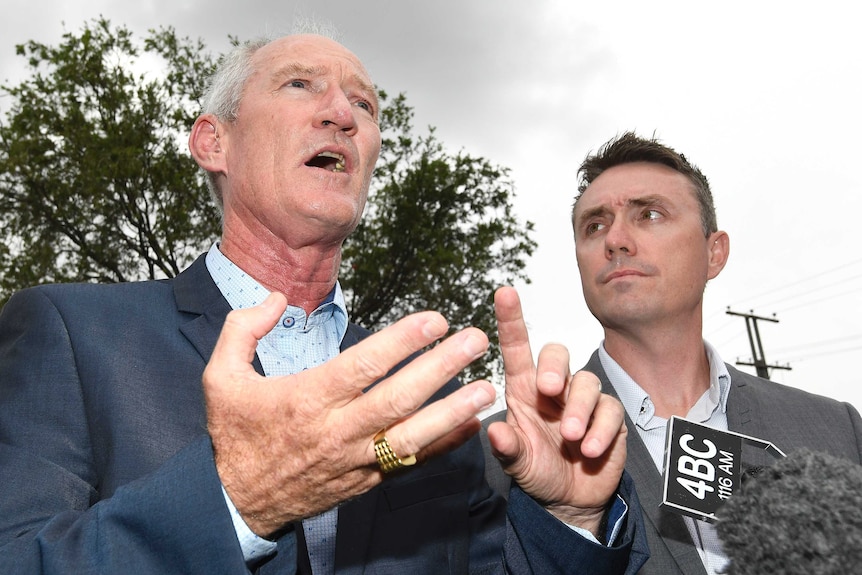 Steve Dickson gestures with his hands while James Ashby looks at him. The shot is from a low angle underneath the men.