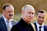 Vladimir Putin in a black shirt and jacket