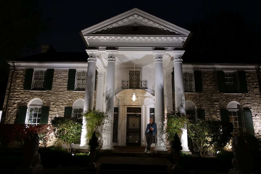 Film director Baz Luhrmann outside Elvis' Graceland at night.