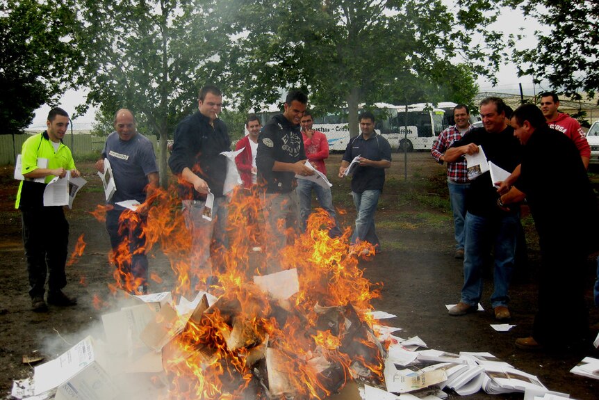 Men burn copies of the Murray-Darling Basin guide.