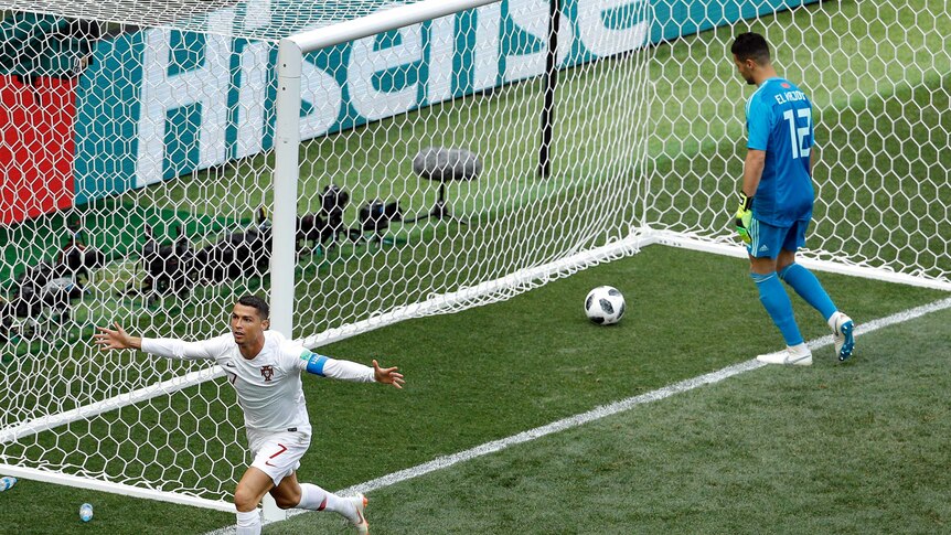 Portugal's Cristiano Ronaldo holds arms wide while goalkeeper pulls goal out of net