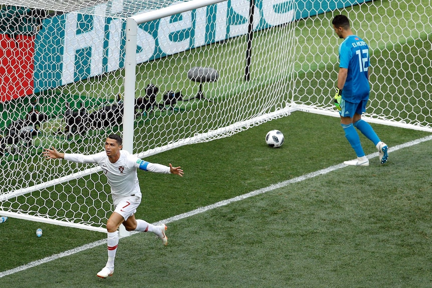 Portugal's Cristiano Ronaldo holds arms wide while goalkeeper pulls goal out of net