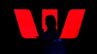 A person is silhouetted against a glowing red W, the Westpac logo.