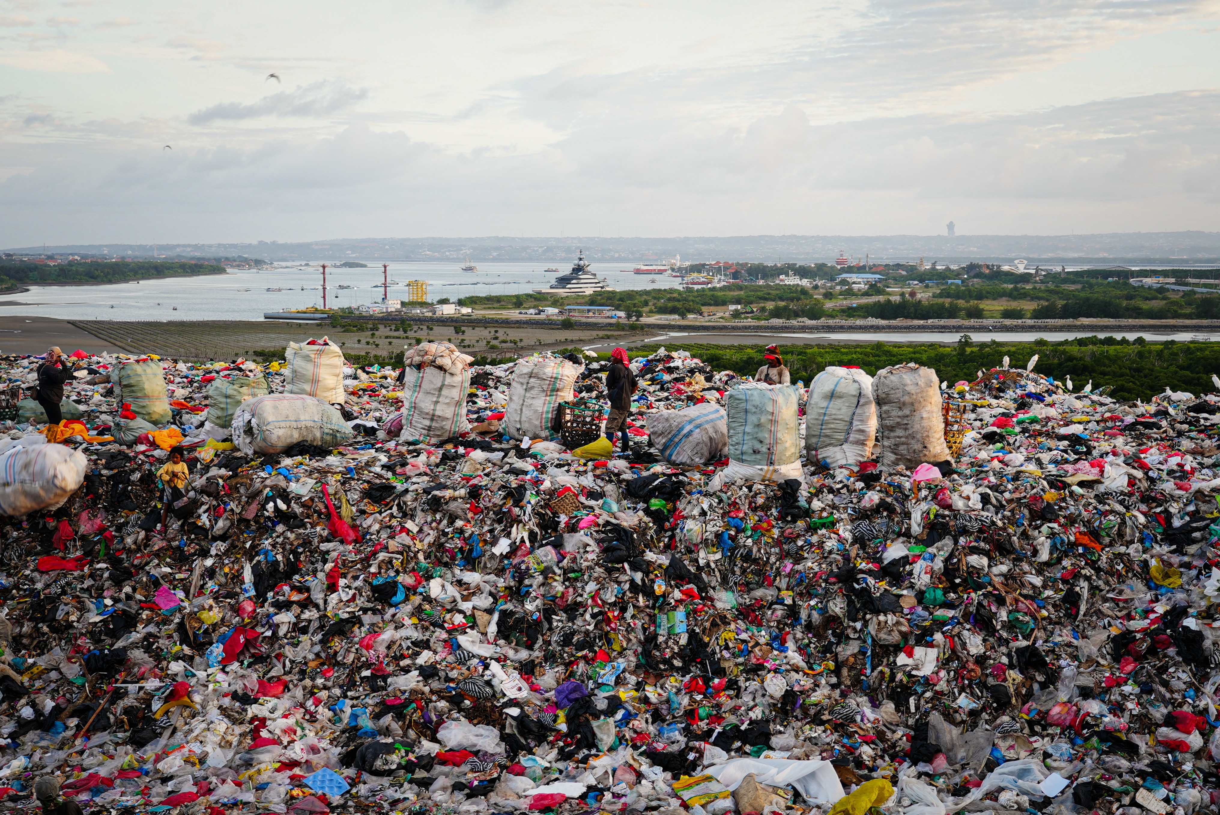 A close up of a pile of trash made of plastic bags and other disposed household items.