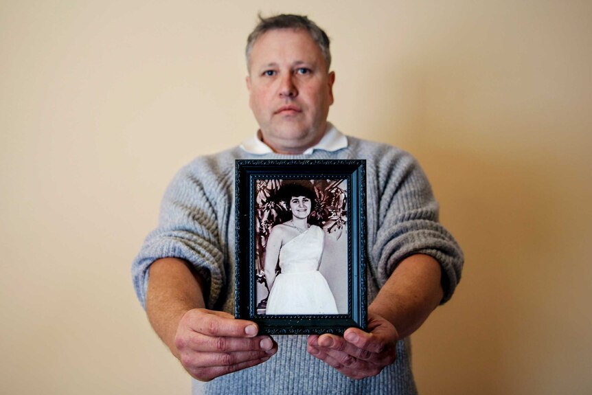 Mark James holds forward a photo of his mother Maria James, who was murdered in 1980.