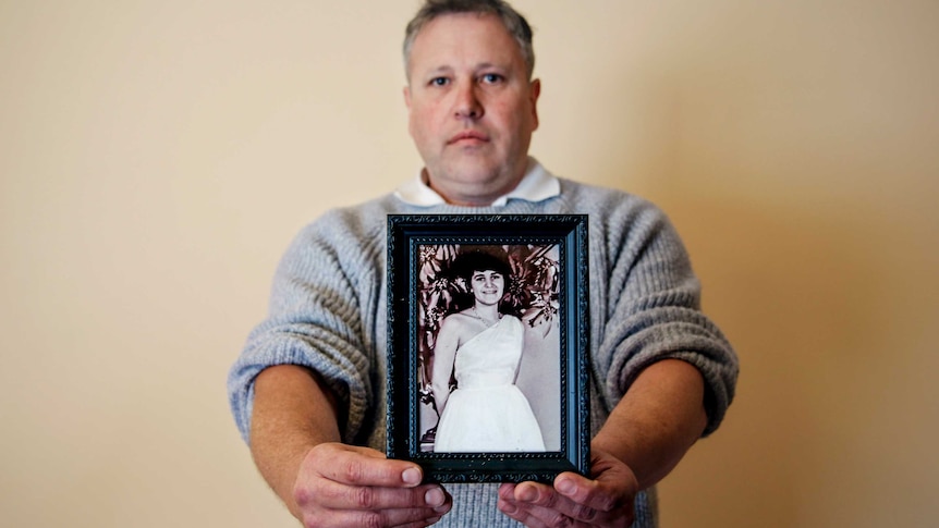 Mark James holds forward a photo of his mother Maria James, who was murdered in 1980.