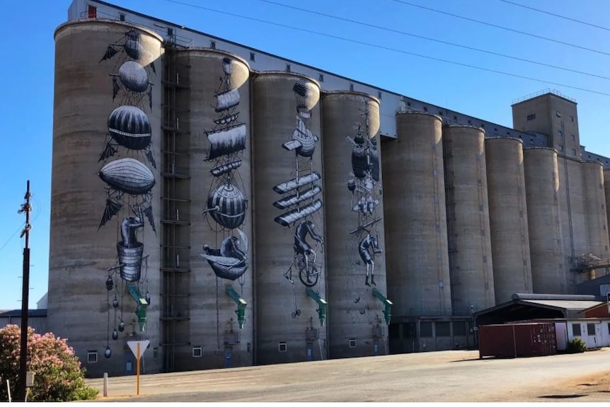 Sixteen silos with art work painted down on eight, art varies between surreal depictions of hot air balloons and abstract colour